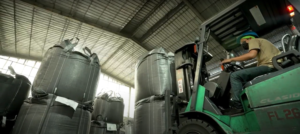 a man operates a forklift to transfer charcoal products