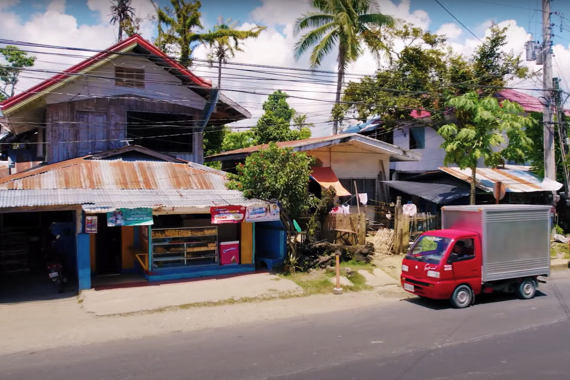 One of the trucks of FAST, a selling and distribution company in the Philippines, approaches a sari-sari store to deliver FMCG products