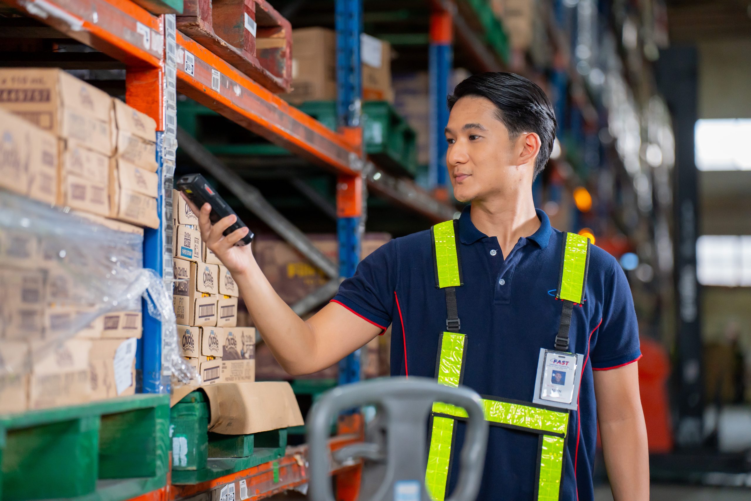 a warehouse staff is using a hub scanner to track and record goods inside a warehouse